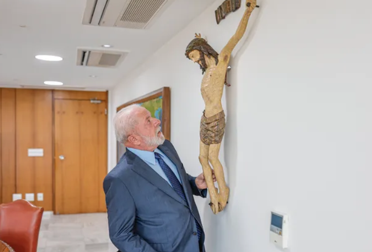 O presidente da República, Luiz Inácio Lula da Silva (PT), com a escultura de Cristo restaurada no gabinete presidencial 