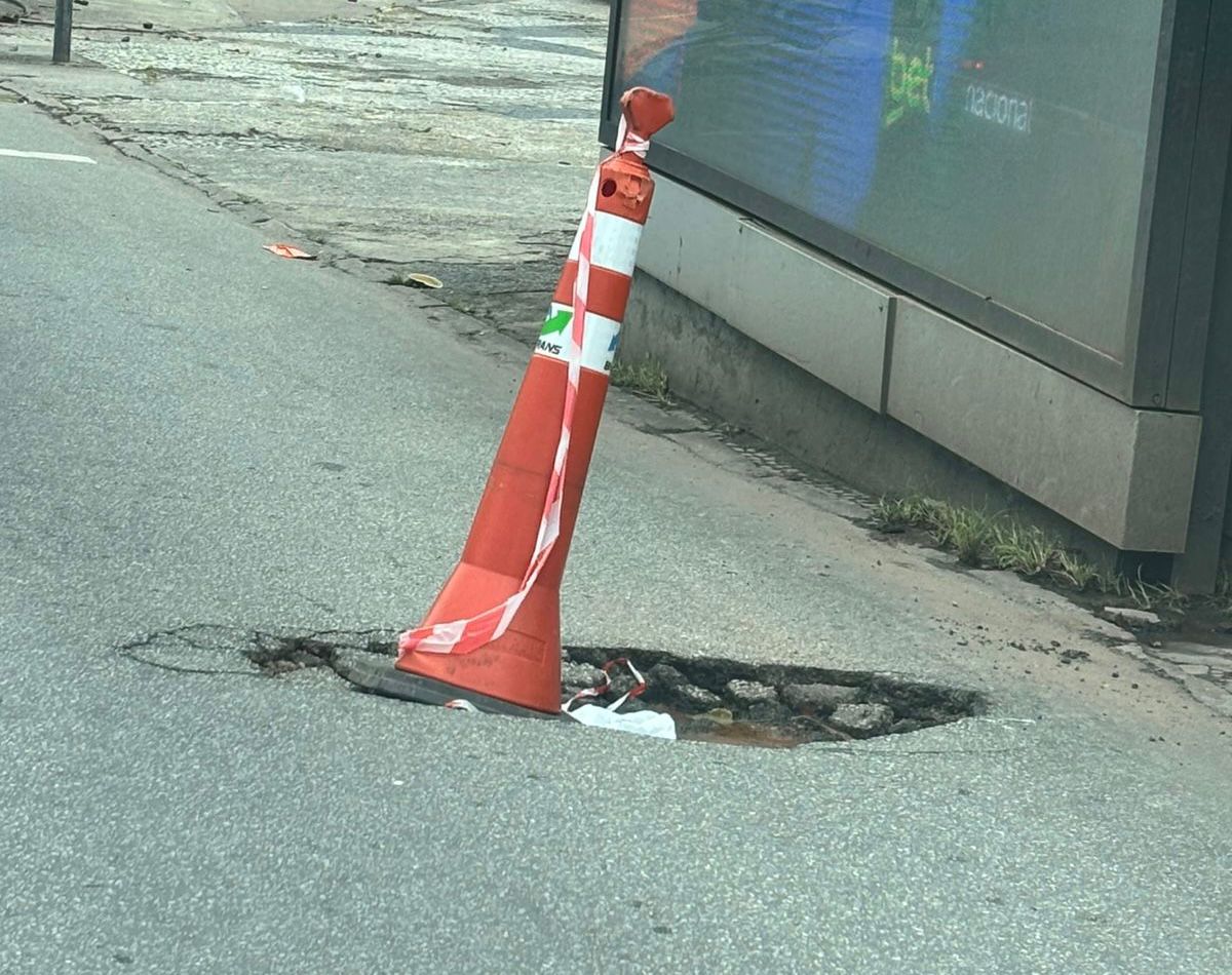 Buraco é sinalizado com cone na avenida Portugal, no bairro Santa Amélia, em BH