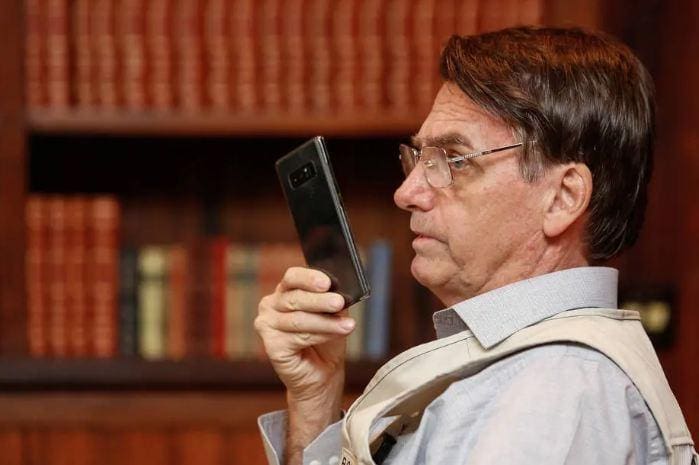Jair Bolsonaro, presidente do Brasil, utiliza o celular para se comunicar