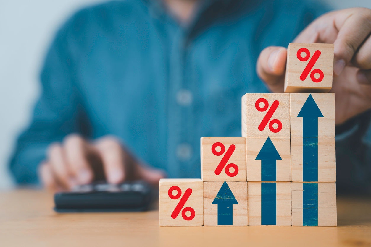Businessman putting red percentage sign with increasing up arrow for financial interest rate and business investment growth from dividend concept.