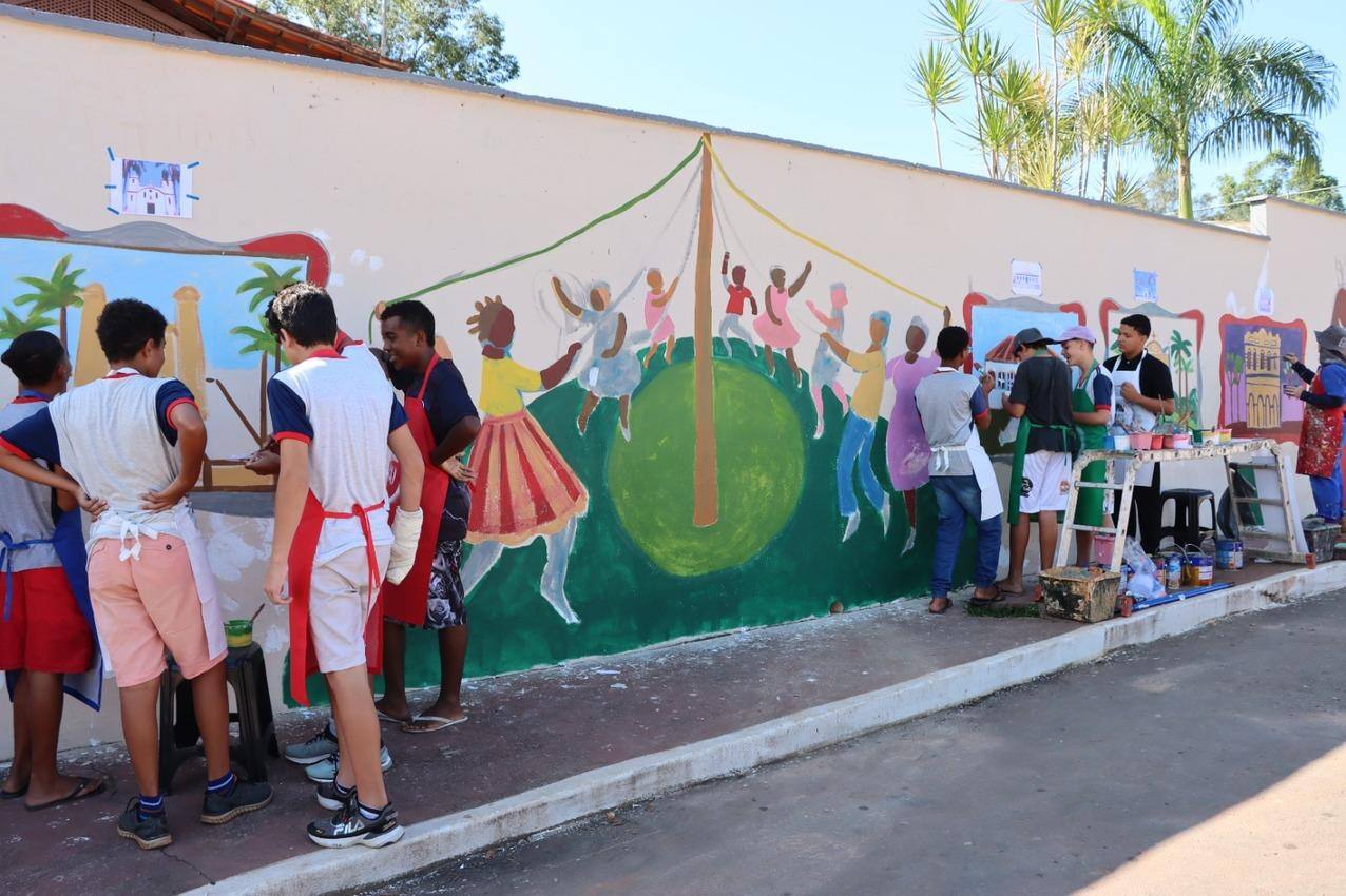 Alunos da E. E. Doutor Gama Cerqueira, em Belo Vale, pintam o muro com os artistas Anna Göbel e Chico Simões