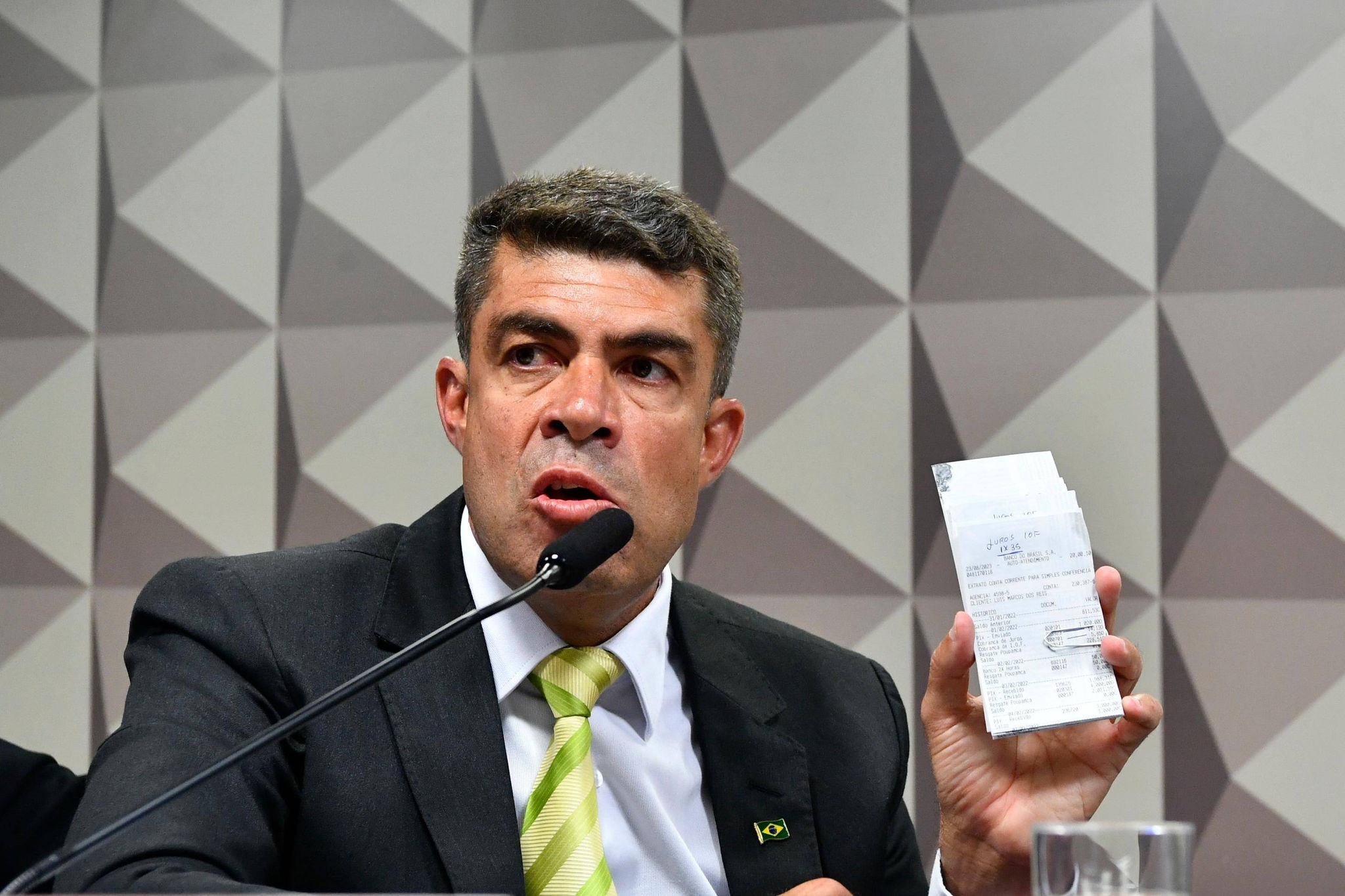 Sargento do Exército, Luis Marcos dos Reis exibe extratos bancários à mesa da CPMI do 8 de janeiro