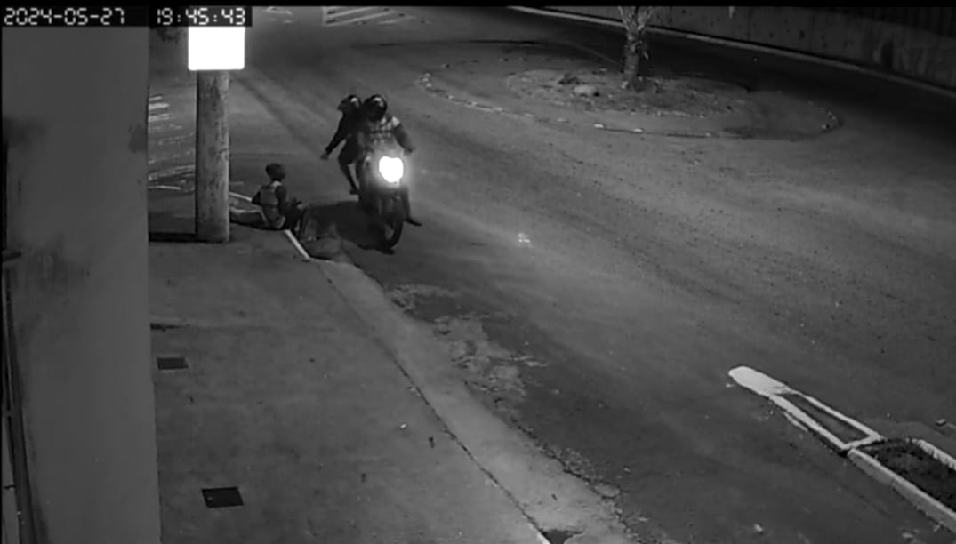 A vítima estava sentada na calçada, na companhia de um cãozinho, interagindo com os vídeos do TikTok, quando foi surpreendida por dois criminosos armados e de moto