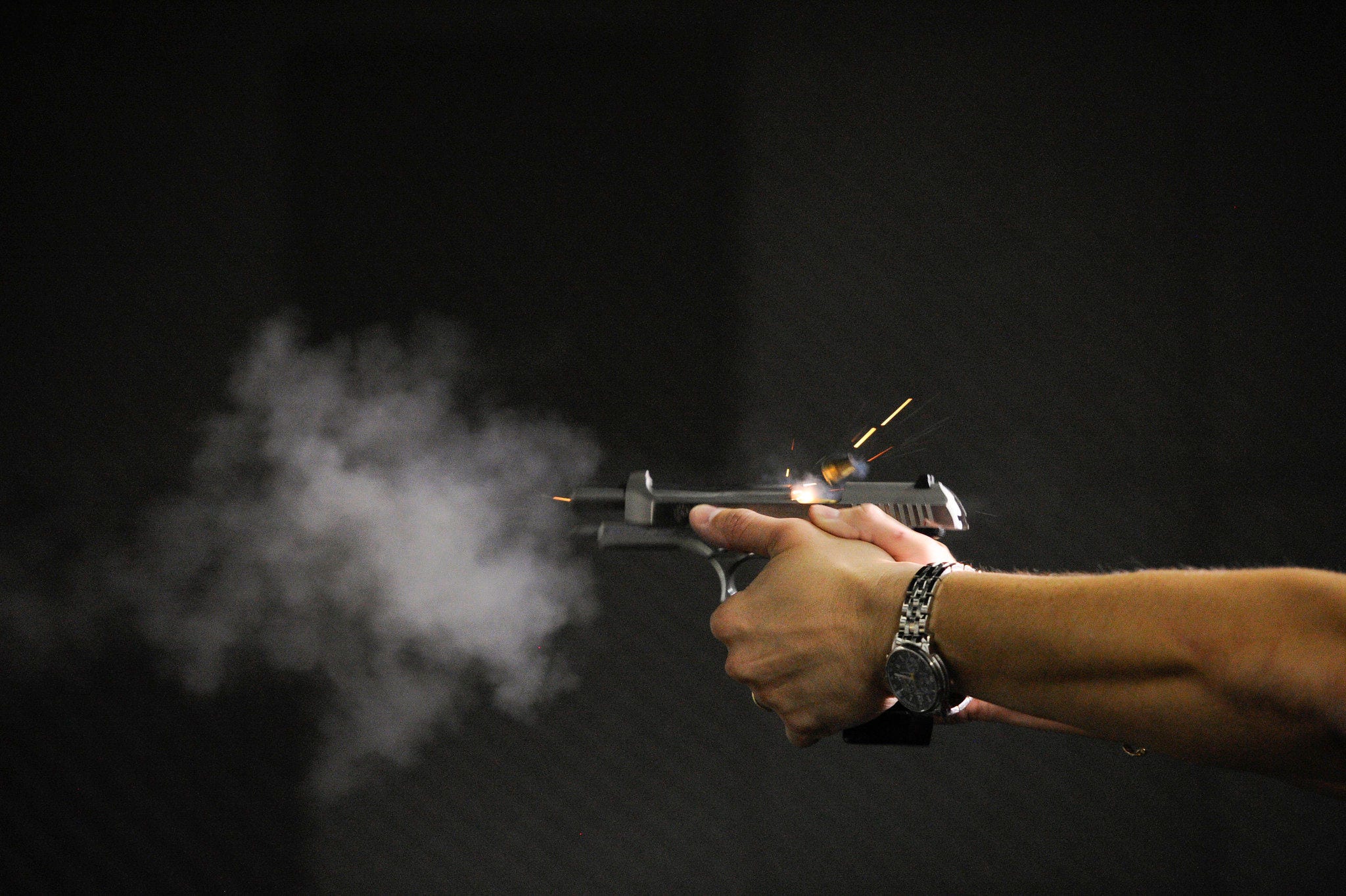 Instrutor de armamento e tiro dispara arma de fogo em estande de clube esportivo de atiradores, caçadores e colecionados de Brasília