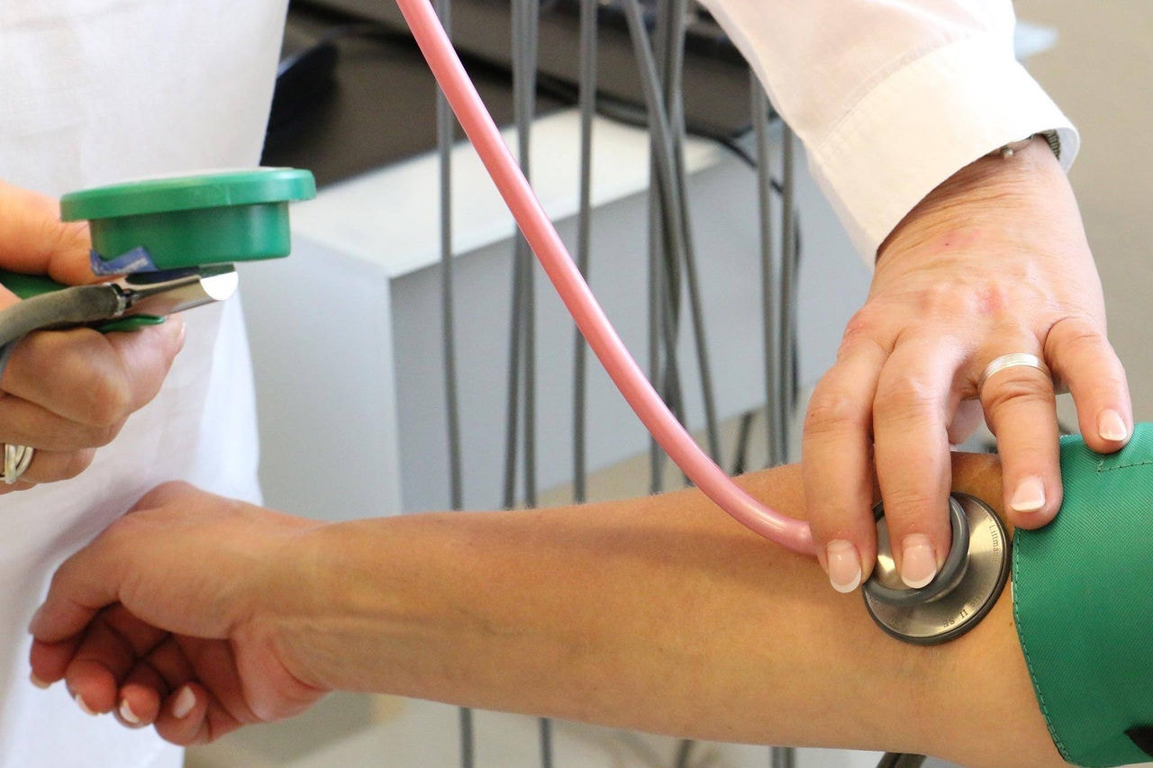 Médico mede pressão de paciente - planos de saúde - exame médico - consulta