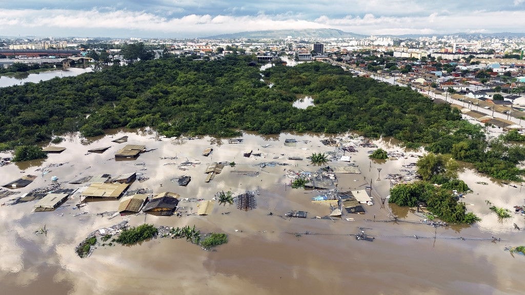 Aerial view of flooded streets at the Sarandi neighborhood in Porto Alegre, Rio Grande do Sul state, Brazil on May 5, 2024. The challenge is titanic and against the clock: authorities and neighbours are trying to avoid an even greater tragedy than the one already experienced in the Brazilian state of Rio Grande do Sul, where 66 people died and 80,000 were displaced by the floods, according to the authorities. (Photo by Carlos Fabal / AFP)