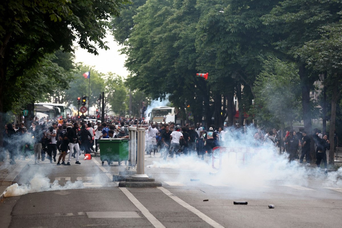 Police officers clash with crowd following the PSG team bus parade, near the Champs-Elysees avenue in Paris on June 1, 2025, a day after PSG won the 2025 UEFA Champions League final football match against Inter Milan in Munich. (Photo by Romain PERROCHEAU / AFP)