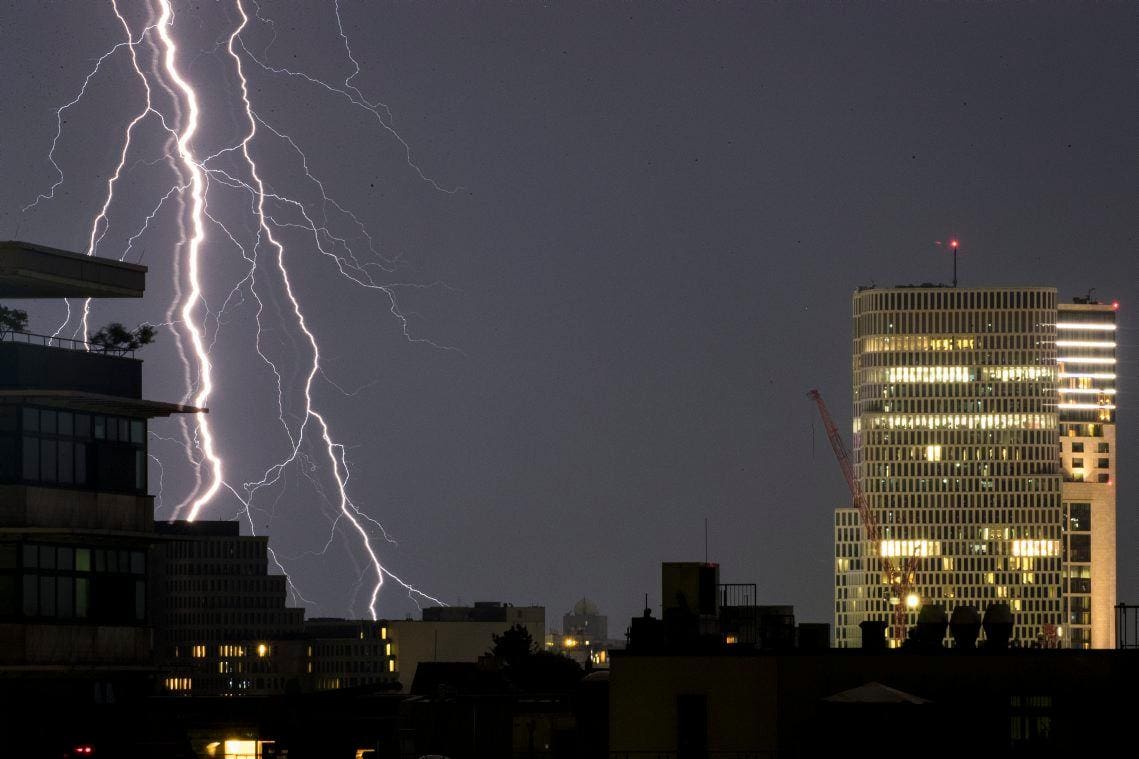 Foto ilustrativa mostra o momento que um raio atinge uma cidade