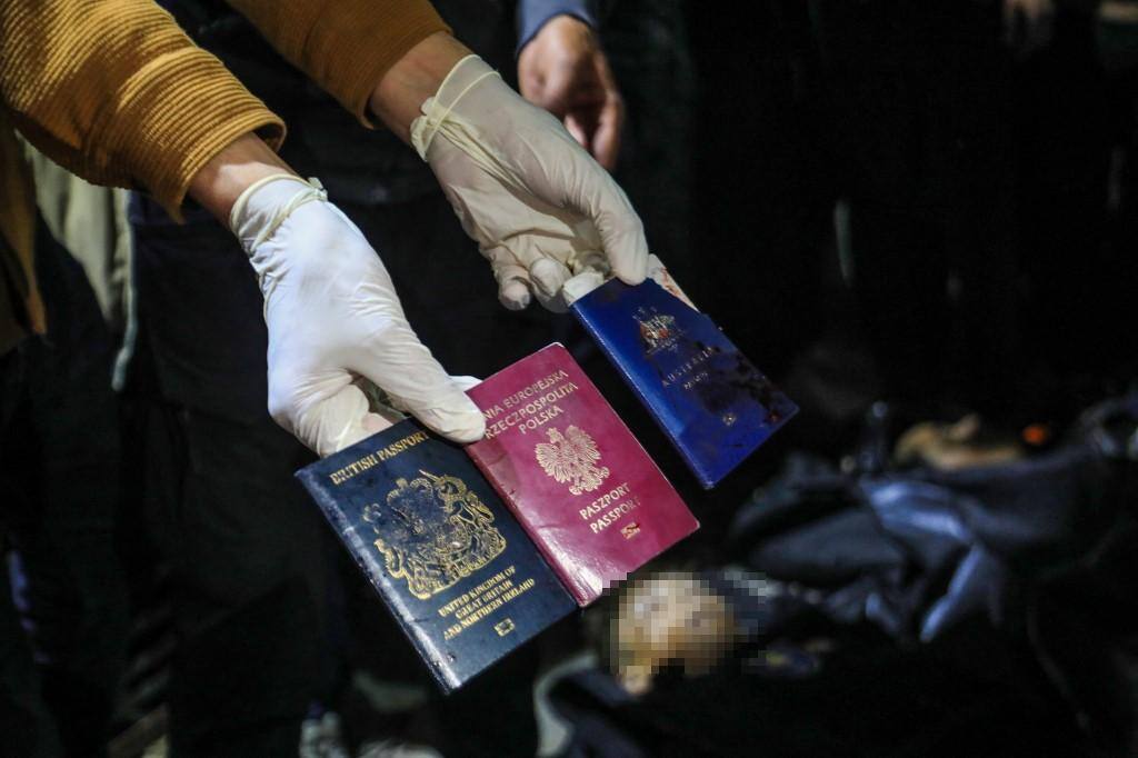 Pessoa segura passaportes de vítimas da Grã-Bretanha, Polônia e Austrália