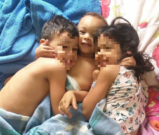 O pequeno Ian abraçado aos seus irmãos, de 7 e 6 anos