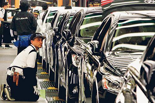 Operário observa veículos na linha de produção da empresa