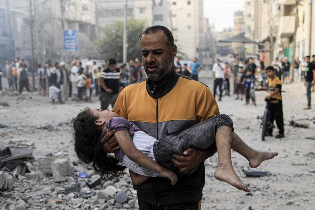 Palestino carrega criança ferida em bombardeio em Khan Younis, na Faixa de Gaza
