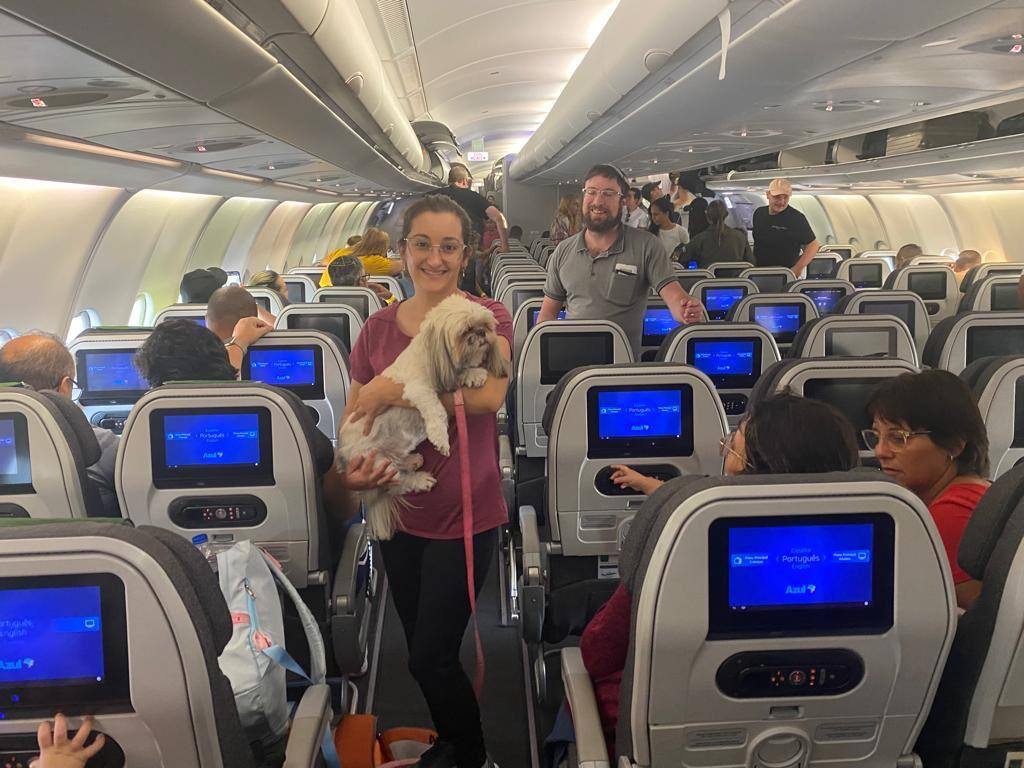 Cachorro com tutora a bordo do avião da FAB que decolou às 11h (hora de Brasília) desta quarta-feira (11) de Tel Aviv para uma escala em Roma com 204 homens e mulheres, cinco bebês de colo e três gatos
