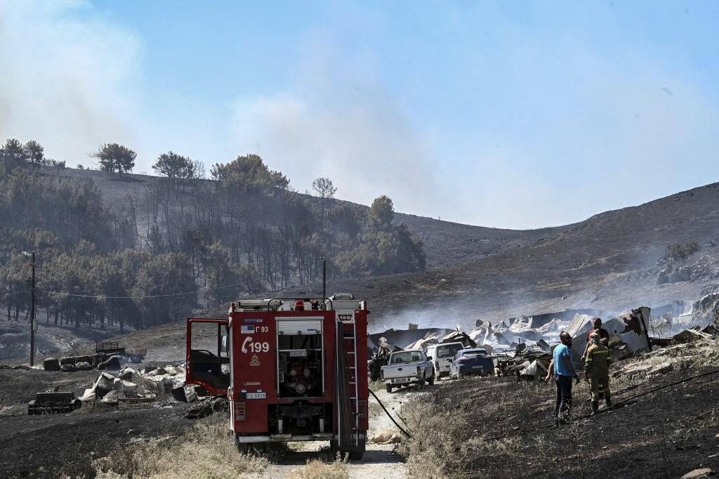 Um caminhão de combate a incêndios está estacionado em uma fazenda, destruída por um incêndio em Feron, em Agios, na Geórgia, perto da cidade de Volos, no centro da Grécia, em 27 de julho de 2023.