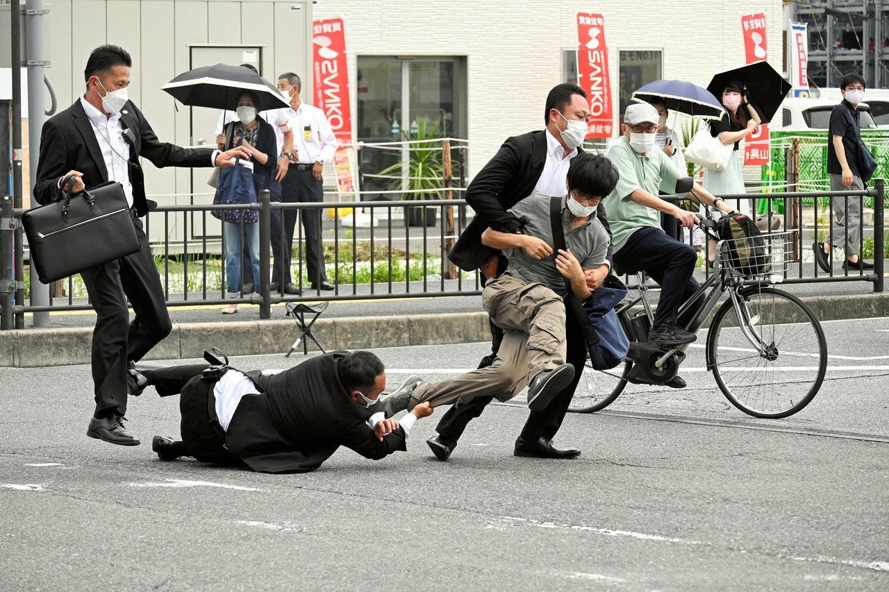 Imagem do jornal Asahi Shimbun mostra o suspeito de atirar no ex-primeiro-ministro japonês Shinzo Abe sendo derrubado pela polícia na cidade de Nara, no Japão.