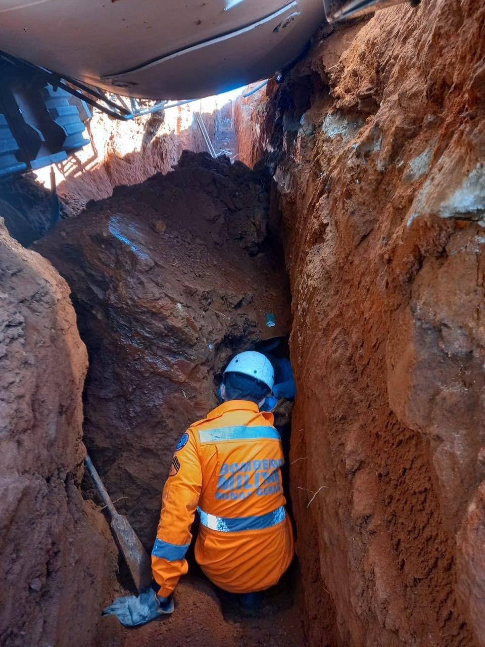 Registro de um militar do corpo de bombeiros tentando acessar a vítima soterrada em vala O caminhão está sobre eles