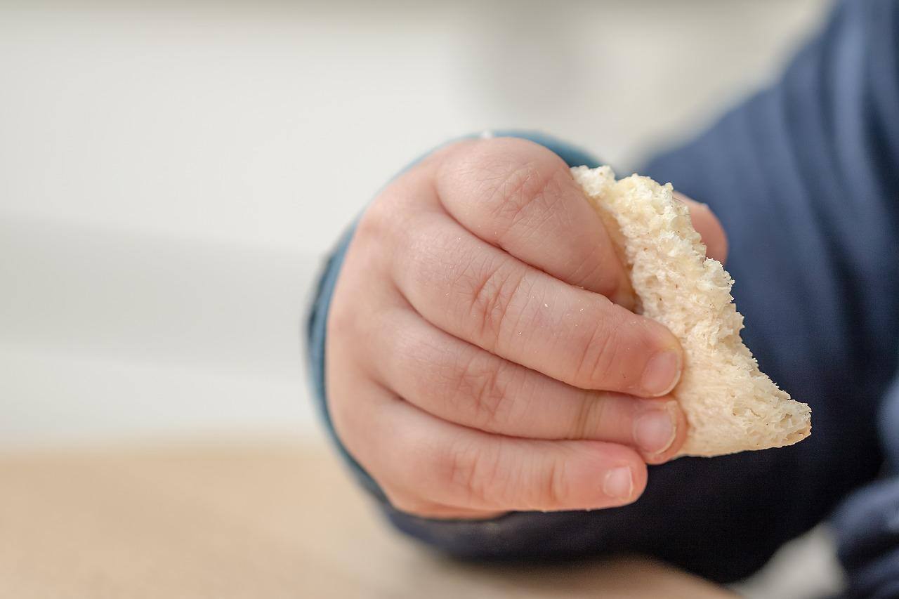 mão de criança comendo