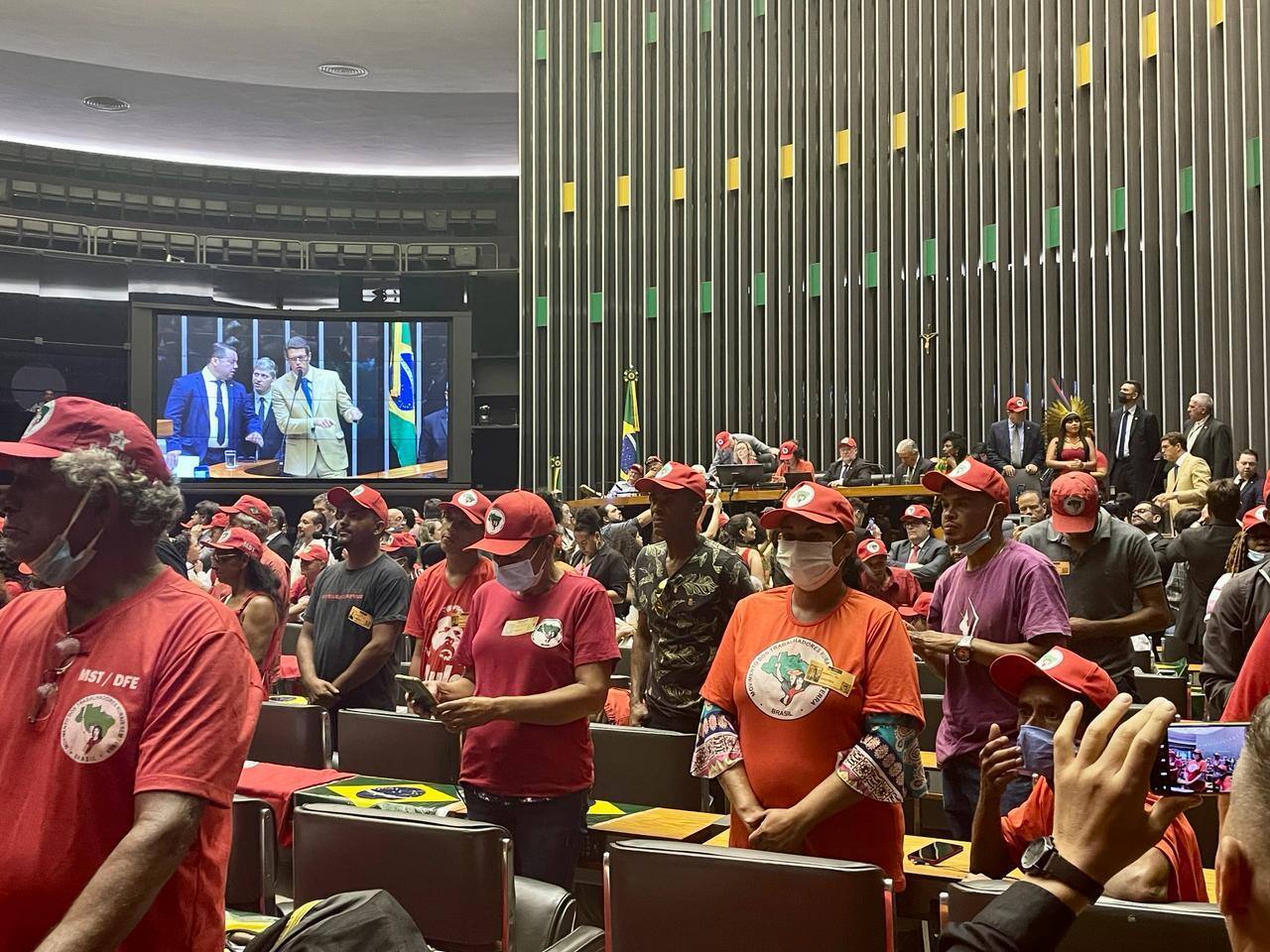 Integrantes do MST protestam e ficam de costas enquanto o deputado Ricardo Salles faz ataques ao movimento na tribuna da Câmara