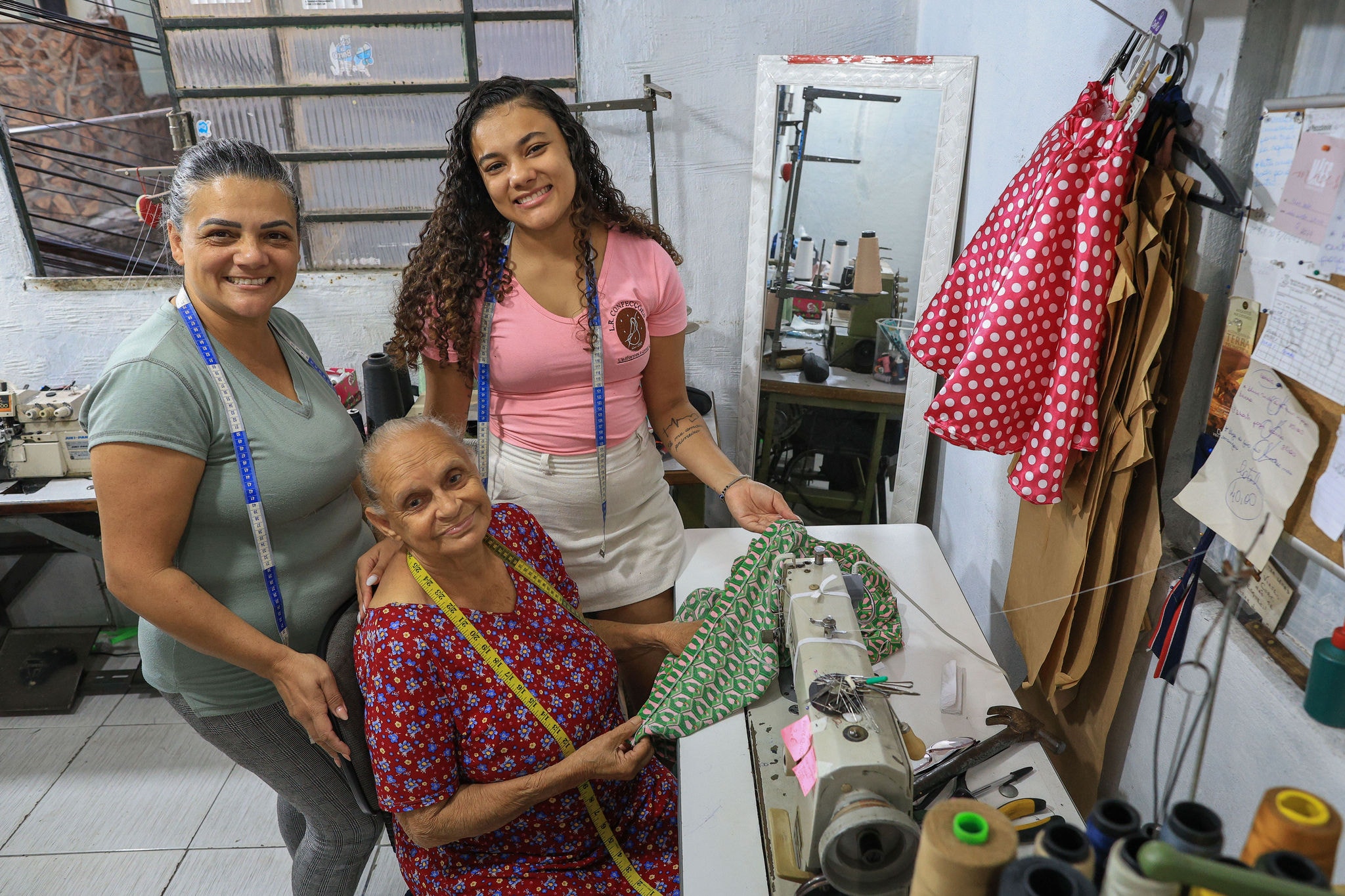 Tayná Roberta (centro) aprendeu a costurar aos 12 anos com a avó paterna , a dona Maria da Penha Ribeiro , hoje com 82 anos; o ofício foi ensinado também para a nora de Maria, Lenilda Gularte, que passou a trabalhar com a sogra 