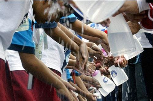 Crianças lavam as mãos durante campanha de conscientização sobre a importância deste simples hábito de higiene, em Jacarta