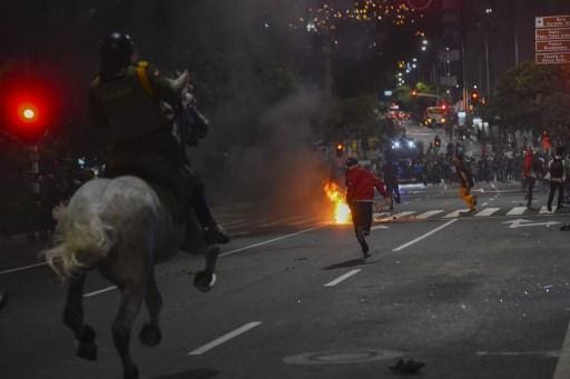 Manifestantes correm enquanto policiais montados os perseguem durante um protesto contra a brutalidade policial em Medellín, Colômbia, em 10 de setembro de 2020