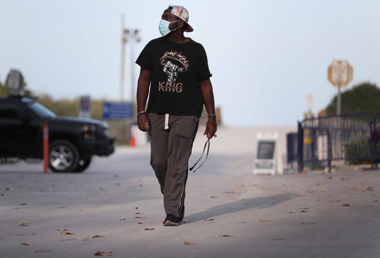 Norte-americano anda por rua perto a hotel onde trabalhava antes da pandemia, na Flórida
