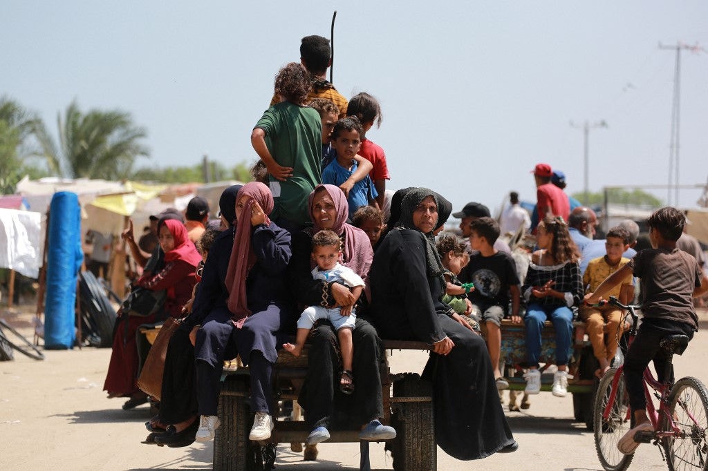 Palestinians ride in an animal-pulled cart in an area housing displaced people in Rafah, in the southern Gaza Strip, on June 19, 2024, amid the ongoing conflict in the Palestinian territory between Israel and Hamas. (Photo by Bashar TALEB / AFP)