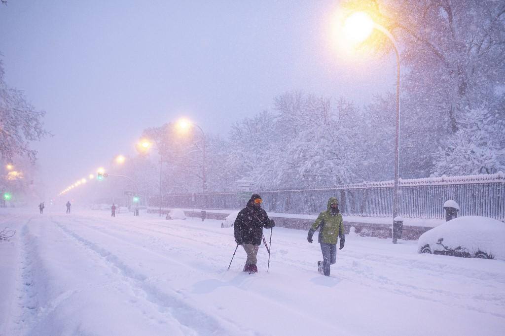 As pessoas caminham em meio a uma forte nevasca em Madrid em 9 de janeiro de 2021. A neve pesada caiu em grande parte da Espanha, deixando enormes áreas cobertas de branco enquanto a tempestade Filomena trouxe um clima invernal não visto há décadas para a Península Ibérica