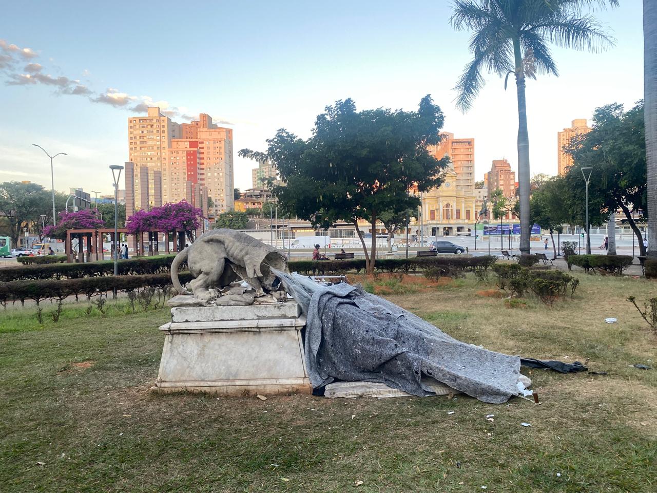 Estátua estragada serve de apoio para abrigo de pessoa em situação de rua