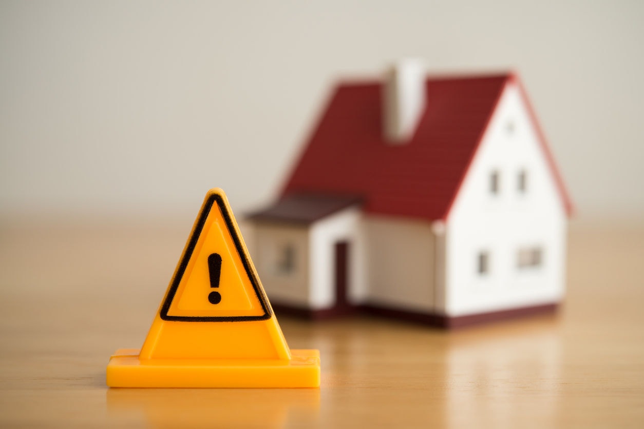 Emergency notification warning sign label with model house background. Mortgage loan for buying home or real estate property, money risk management in financial, foreclosure and bankruptcy  concept.