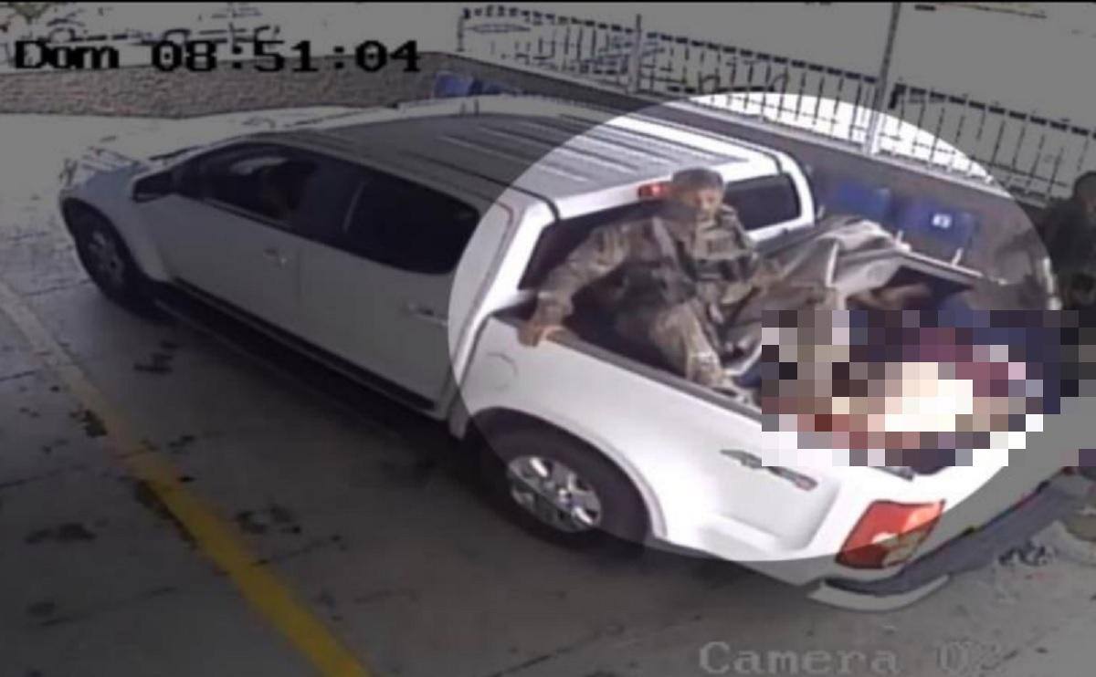 Imagem de câmera de segurança de um dos hospitais, anexada no inquérito, mostra policial sentado sobre os corpos