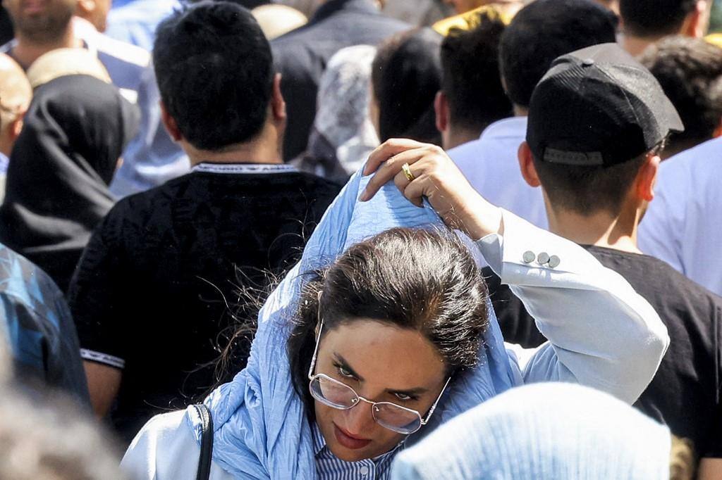 Mulher ajusta véu no Irã