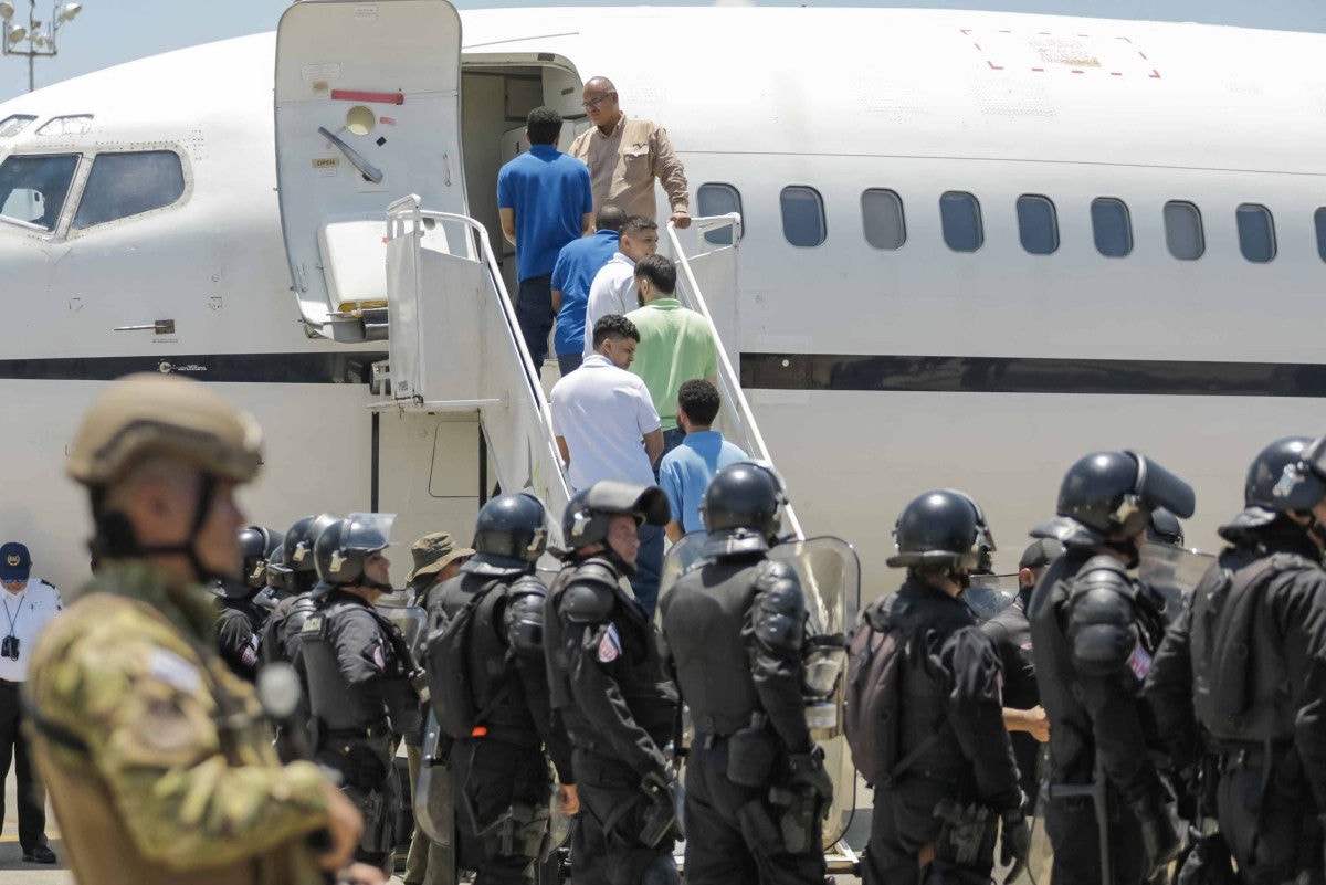 Migrantes venezuelanos embarcam de volta para o país após saírem de detenção em El Salvador