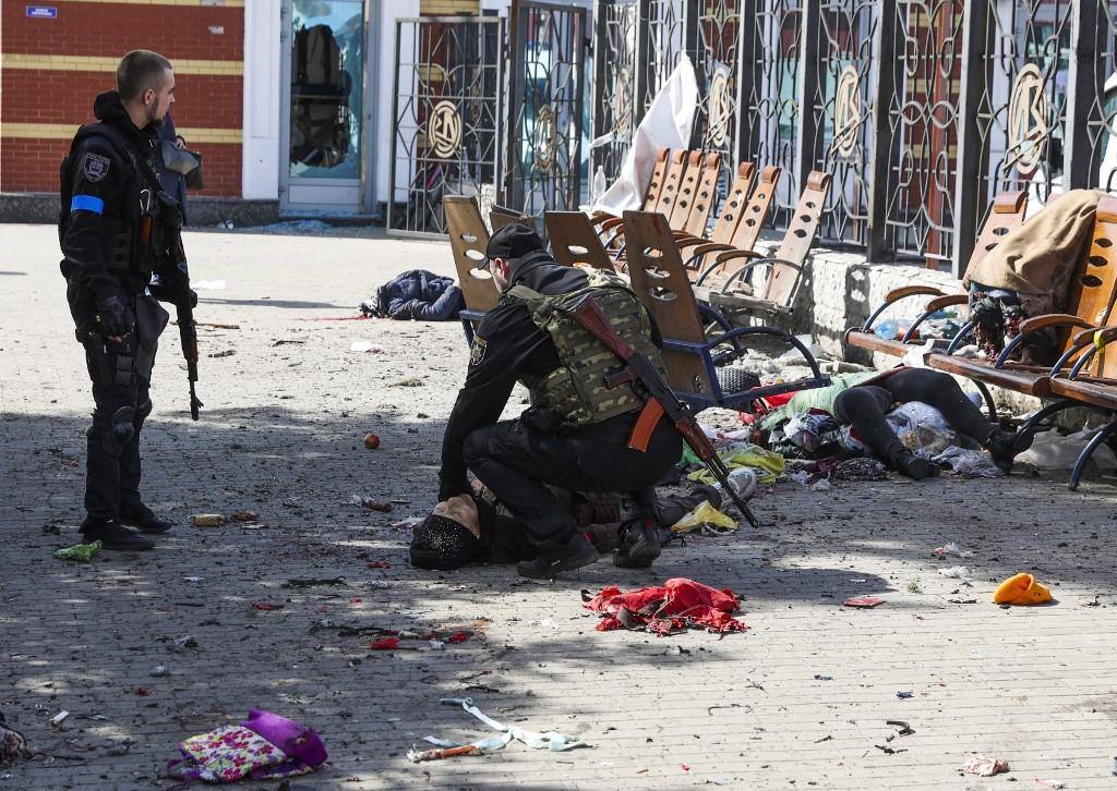 Militares ucranianos verificam sinais de vida entre as vítimas deitadas na plataforma após um ataque com foguete na estação ferroviária em Kramatorsk, na região de Donbas