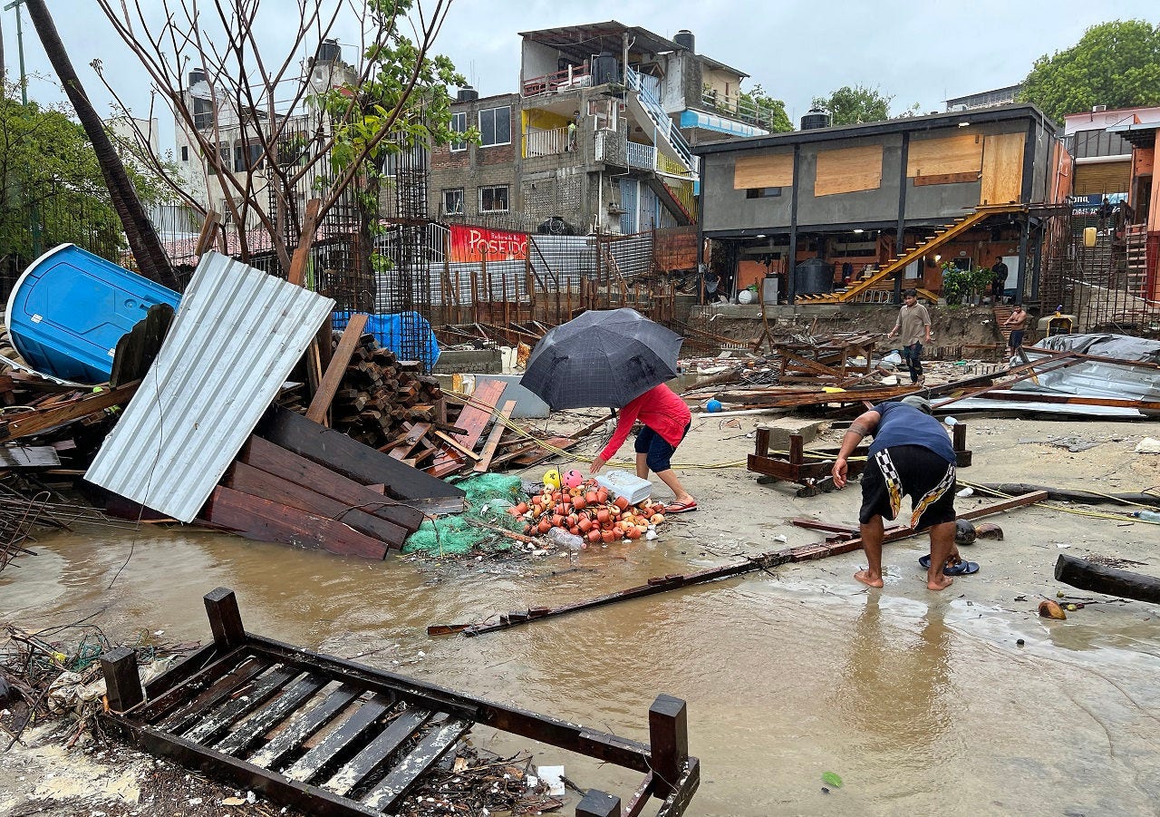 Locals walk amid debris following the passage of Hurricane Erick in Bahia Principal, Puerto Escondido, state of Oaxaca, Mexico, on June 19, 2025. Erick, a category 4 hurricane on a scale of 5, made landfall in the Mexican state of Oaxaca (west) on the Pacific coast, the United States National Hurricane Center (NHC) reported. (Photo by CARLO ECHEGOYEN / AFP)