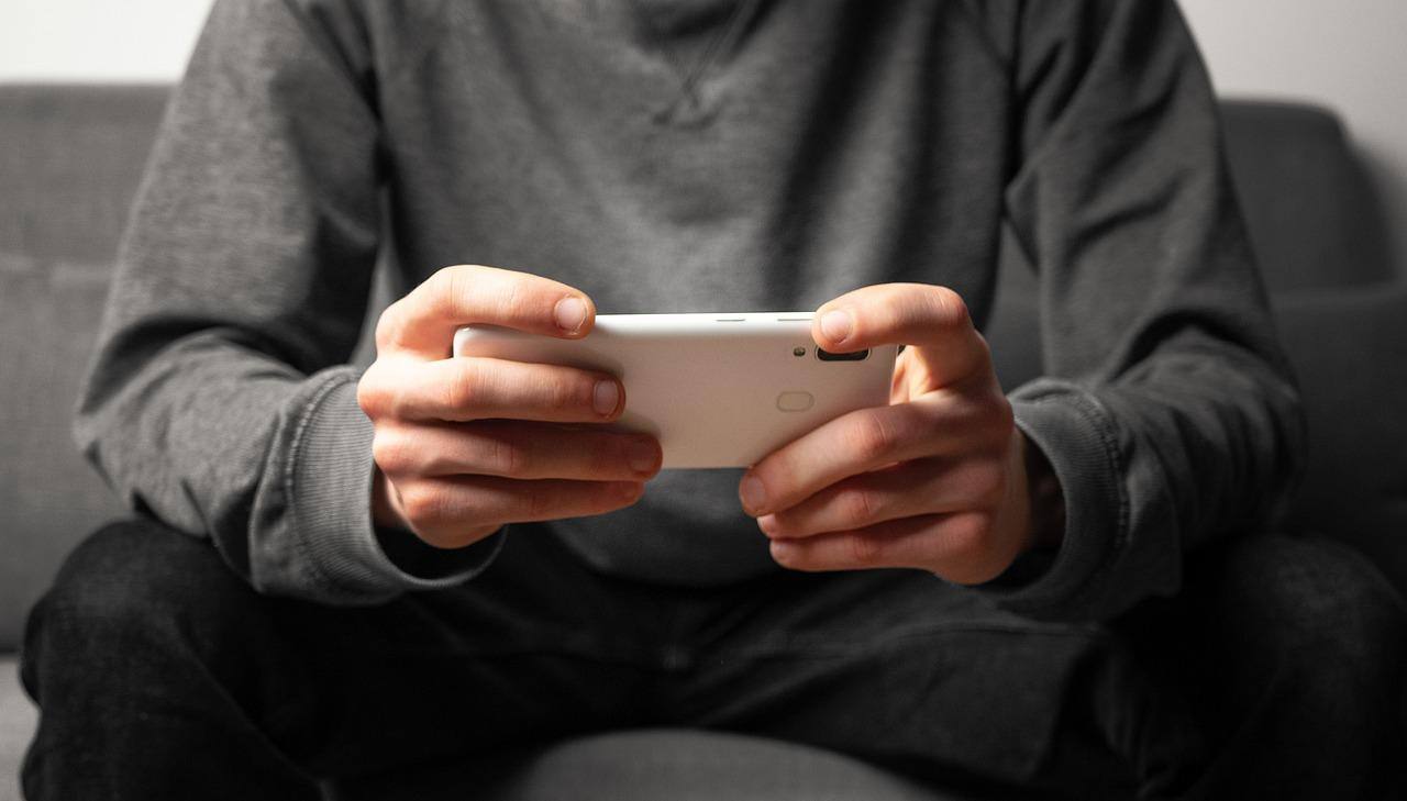 Imagem mostra pessoa mexendo no celular, sem identificá-la