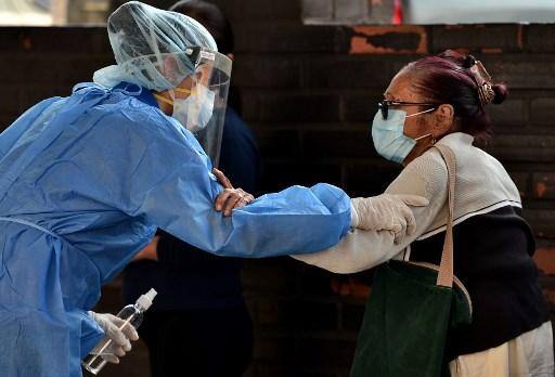 Uma enfermeira em EPI (equipamento de proteção individual) atende uma idosa na sala de emergência do Instituto de Seguridade Social de Honduras, durante a pandemia do novo coronavírus COVID-19, em Tegucigalpa,