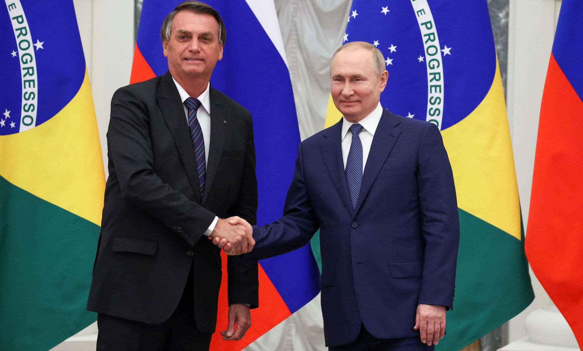 Os presidentes Jair Bolsonaro e Vladimir Putin apertam as mãos após reunião no Kremilin, sede do governo russo