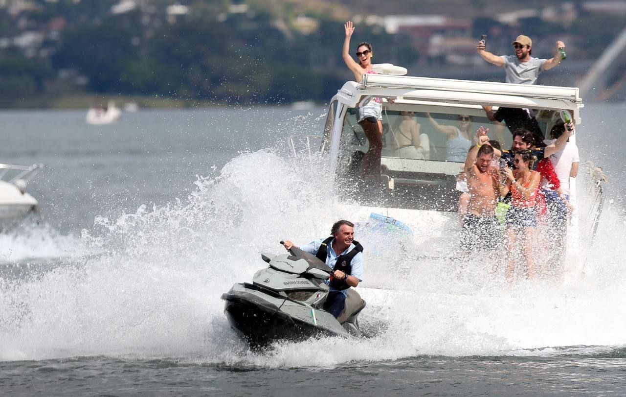 O presidente Jair Bolsonaro passeia de Jet Ski em meio a barcos que participam de uma 'lanchaciata' em seu apoio no lago Paranoá