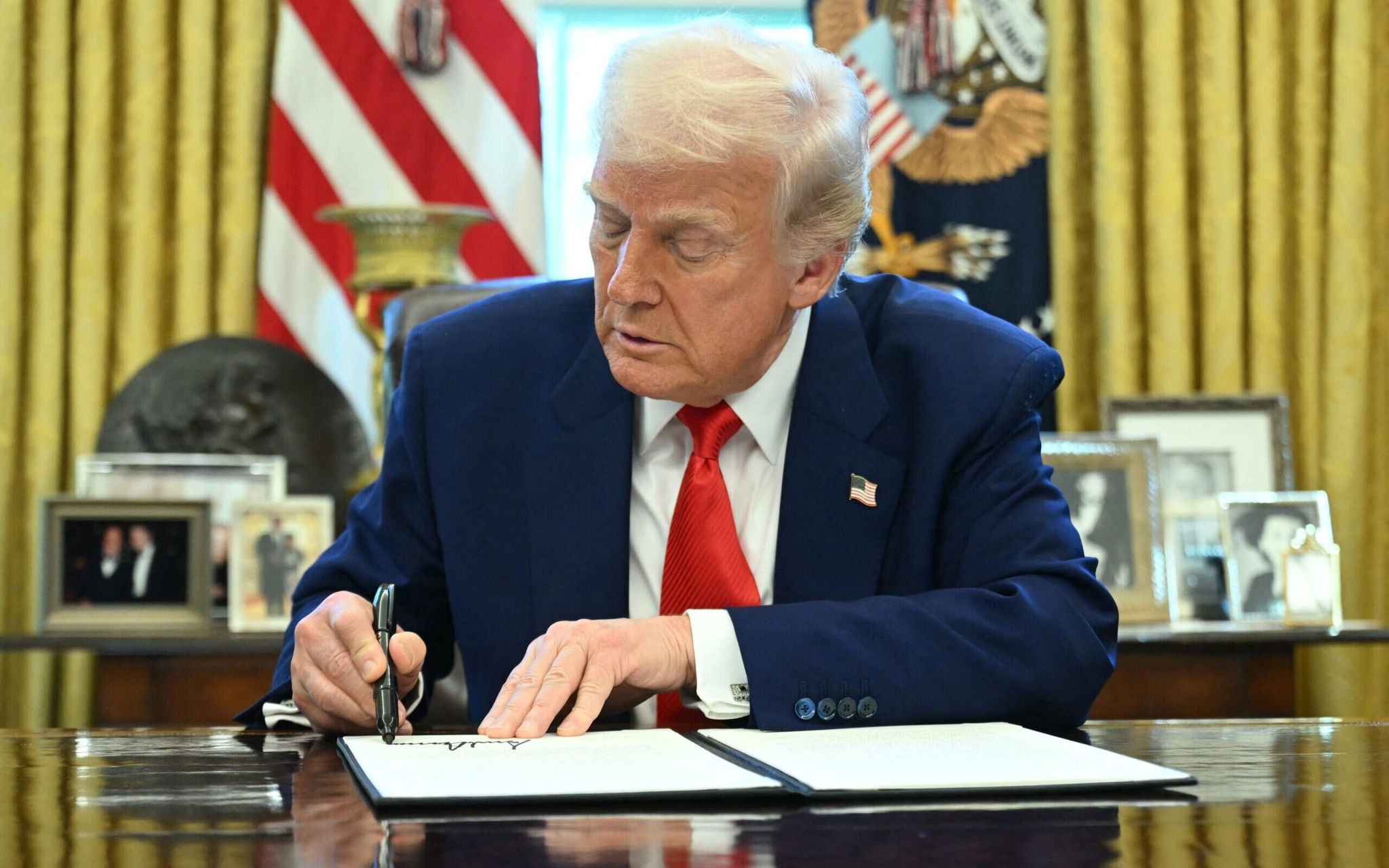 Presidente Donald Trump assina decreto no salão oval da Casa Branca (Foto: Saul Loeb/AFP)