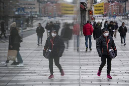 Uma mulher usando uma máscara protetora é mostrada refletida em uma janela em Estocolmo, Suécia, onde escolas primárias, restaurantes e bares estão abertos e as pessoas são encorajadas a sair para tomar um pouco de ar, enquanto o resto da Europa está trancado em uma tentativa de conter a propagação do COVID-19