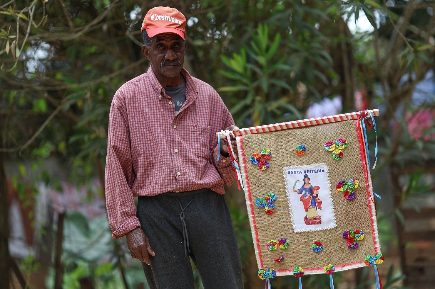 Seu Paulo, 76, mostra bandeira da folia de reis, tradição mantida viva na comunidade