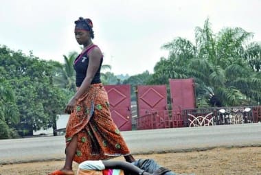 Mulher passa por uma suposta vítima do vírus ebola, na Libéria