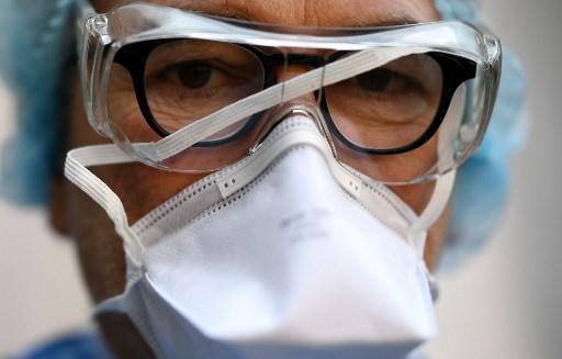 Um médico fica do lado de fora do centro de controle de triagem reservado para profissionais de saúde