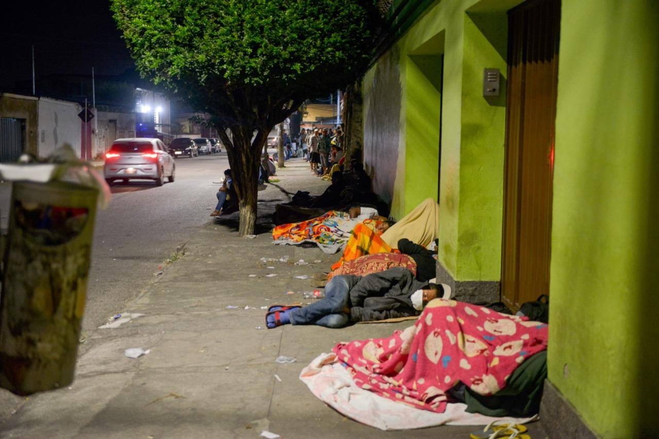 Pessoas dormem em papelões em frente à agência da Caixa para tentar atendimento