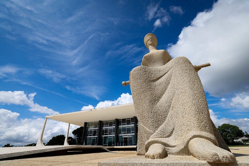 Fachada do Palácio do STF ao fundo com destaque para a escultura A Justiça, em primeiro plano