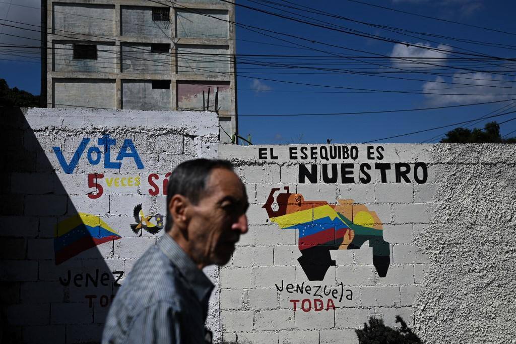 Venezuelano passa por muro onde está pintada uma campanha pela anexação de Essequibo
