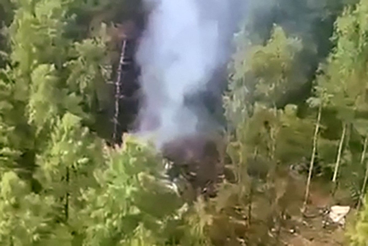 Imagens do local do acidente divulgadas pela mídia estatal russa mostram destroços espalhados pela densa floresta, cercados por colunas de fumaça
