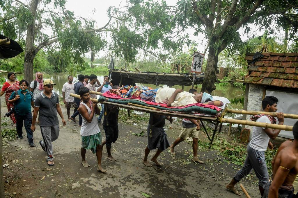Moradores carregam homem que teve perna quebrada por árvore durante a passagem do ciclone; em muitas áreas da Índia e de Banglasdesh, veículos socorro não conseguem chegar