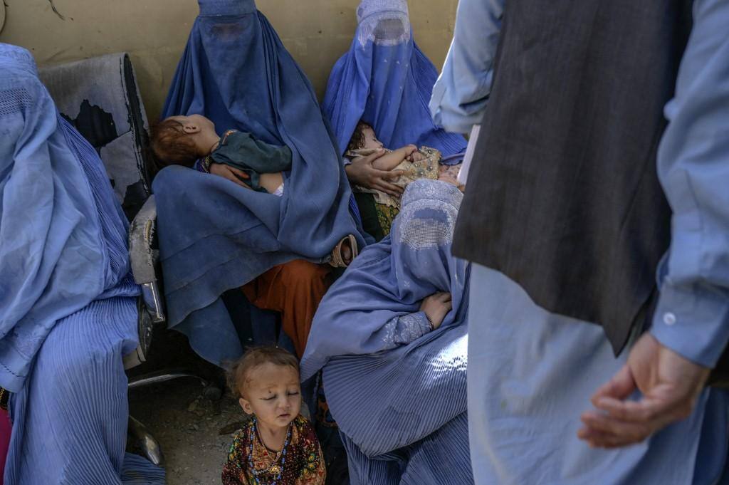 Mulheres vestido burca, indumentária recomendada pelo regime talibã, sentam-se com suas crianças na cidade de Spin Boldak, fronteira do Afeganistão com o Paquistão